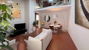 Una sala moderna con sofá, mesa de comedor y televisor.