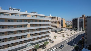 A multi-story hotel with a modern design, featuring a central courtyard and a parking area.