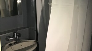 Um banheiro com pia, espelho e cortina de chuveiro.