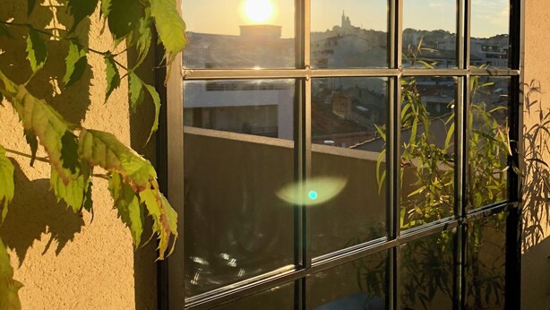 A window with a view of a cityscape and a clear sky. - Appartement en Étage Élévé Avec Terrasses (Marseille)