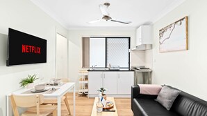 Un appartement moderne comprenant un coin repas, un salon et une cuisine.
