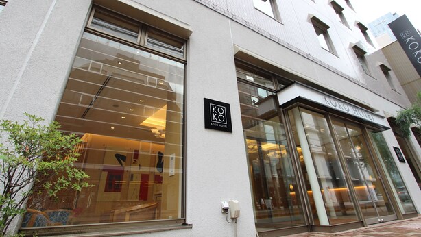 A modern building with a glass facade, a sign for Koko Hotel, and a visible entrance. - KOKO HOTEL Sendai Station South (Sendai)