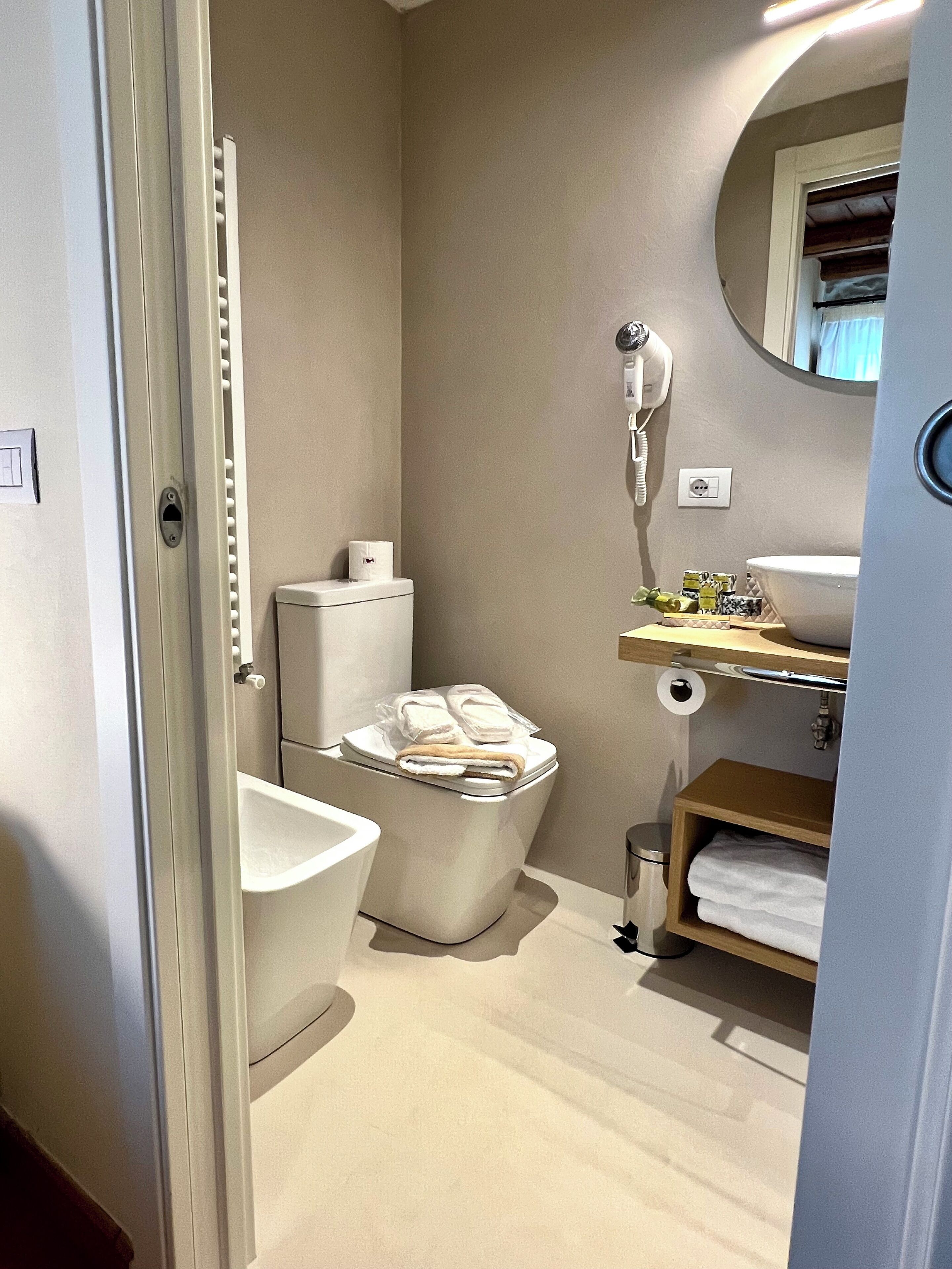Une salle de bain moderne équipée de toilettes, d’un bidet et d’un meuble-lavabo avec un miroir.