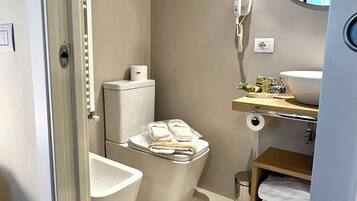 Une salle de bain moderne équipée de toilettes, d’un bidet et d’un meuble-lavabo avec un miroir.