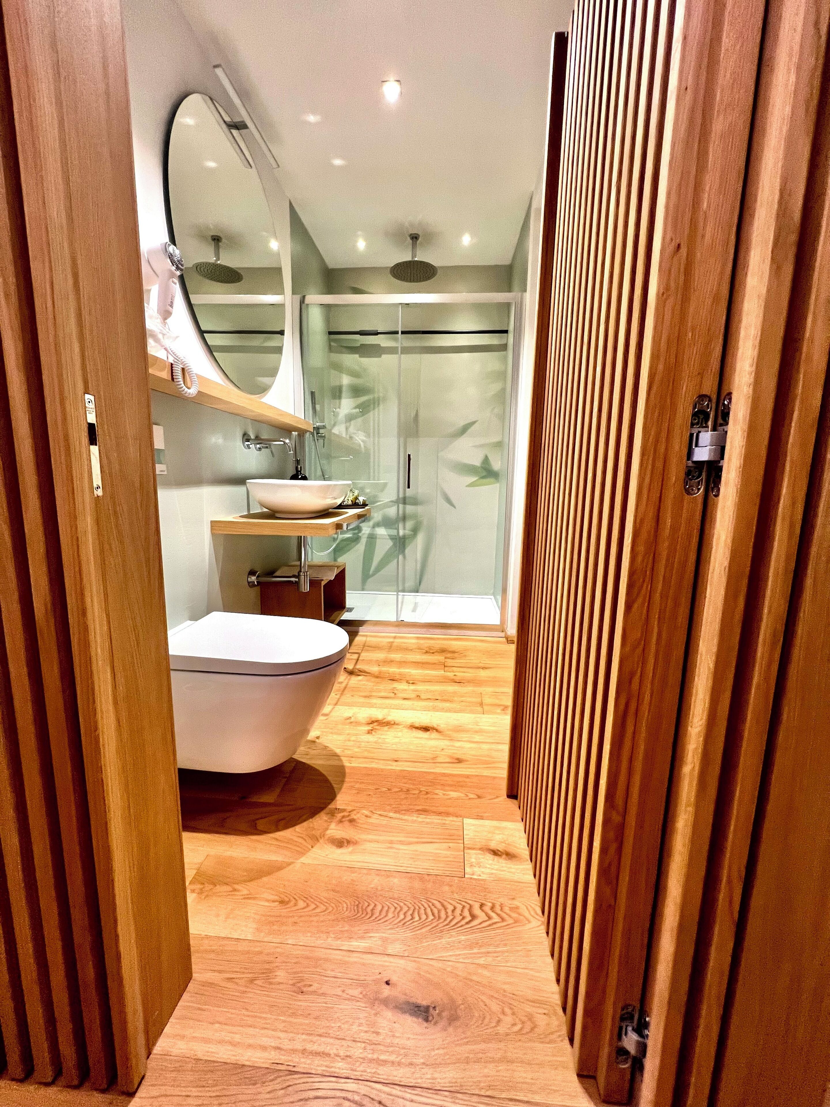 Un baño moderno con una bañera independiente, un tocador con espejo y una ducha con mampara de cristal.