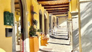 A corridor with wooden beams, stone steps, and a yellow wall. - Nobilia Dimore - Suite & Spa (Pratovecchio Stia)
