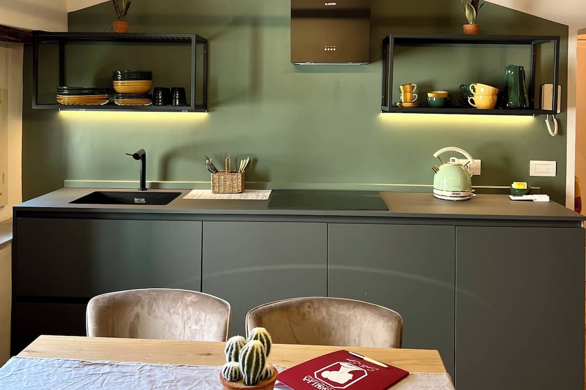 Uma cozinha moderna com ilha central, eletrodomésticos embutidos e área de refeições com mesa e cadeiras.