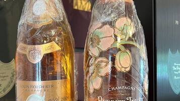 Two bottles of champagne, Louis Roederer and Perrier Jouet, wrapped in plastic.