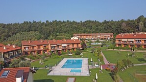 Un hotel con varias edificaciones, piscina y césped bien cuidado.