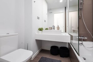 Un baño moderno con inodoro, lavamanos y ducha.