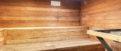 Una sauna de madera con un banco y escalones.