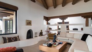 A modern living room with a sofa, coffee table, and fireplace.