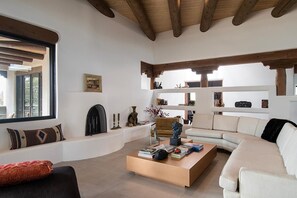 A modern living room with a sofa, coffee table, and fireplace. - Takoda (Santa Fe)