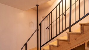 A wooden staircase with black metal railings and a handrail.