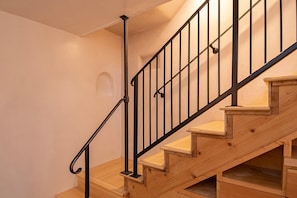 Una escalera de madera con barandillas y pasamanos de metal negro.