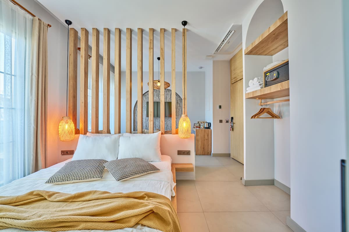 Een moderne hotelkamer met een bed, houten latten en twee wandlampen.