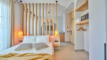 Una habitación de hotel moderna con una cama, listones de madera y dos lámparas fijadas a la pared.