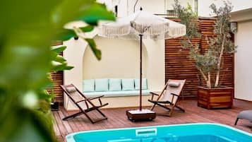 Una piscina con sillones de descanso y un espacio para sentarse.