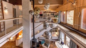 A multi-level interior with a fireplace, seating areas, and a view of the outdoors. - Large chalet, peaceful setting ideal for Cham adventures, Flégère & Grand Montet (Chamonix-Mont-Blanc)