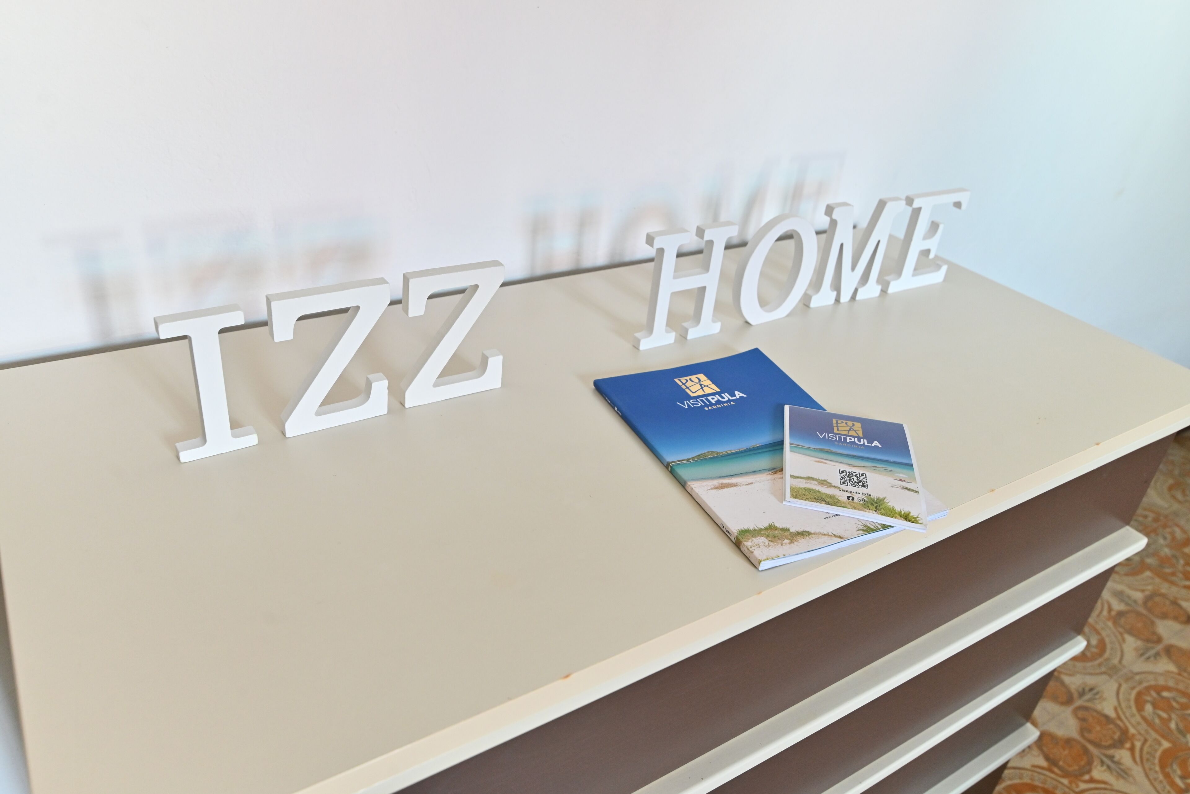 Uma receção com sinalética 'IZZ HOME' e um folheto.