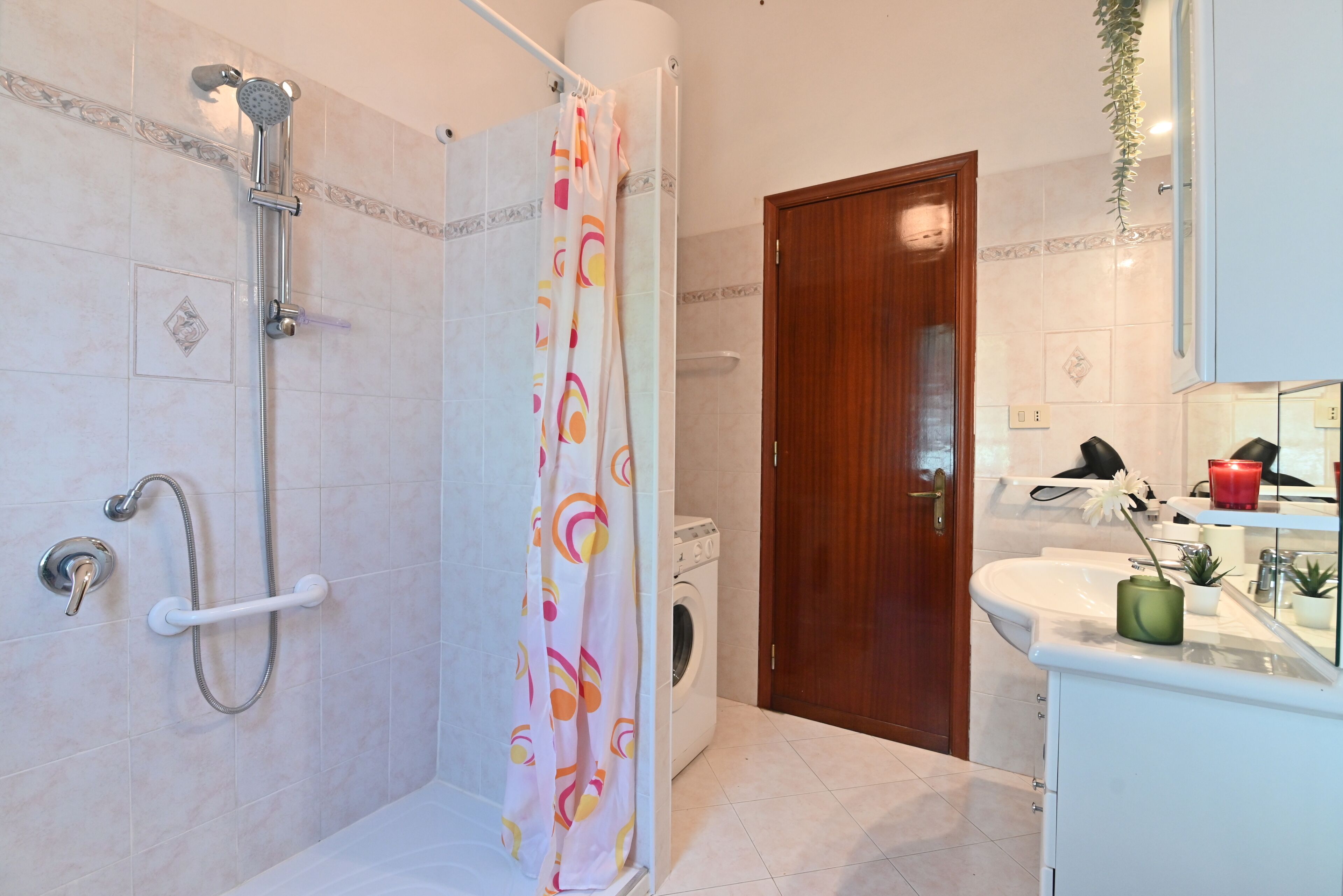 A bathroom with a shower, a toilet, a sink, and a mirror.