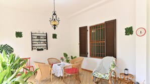 Una habitación acogedora con muebles de mimbre, un suelo estampado y una estantería.