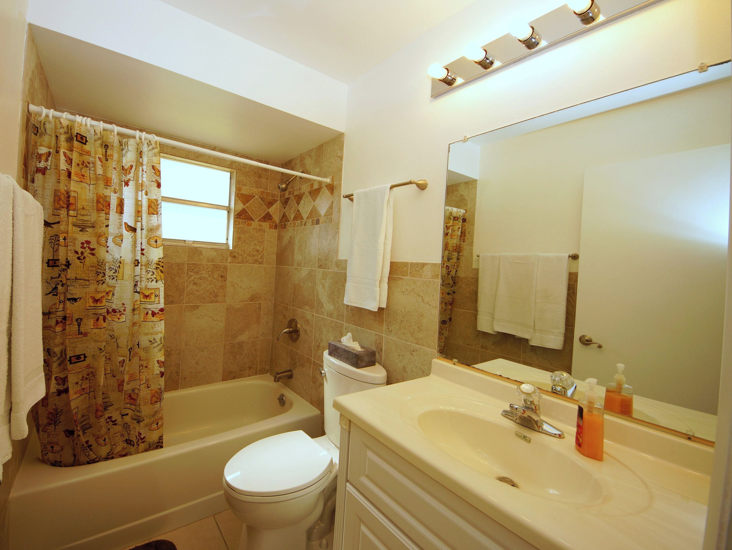 A bathroom with a bathtub, toilet, and sink.
