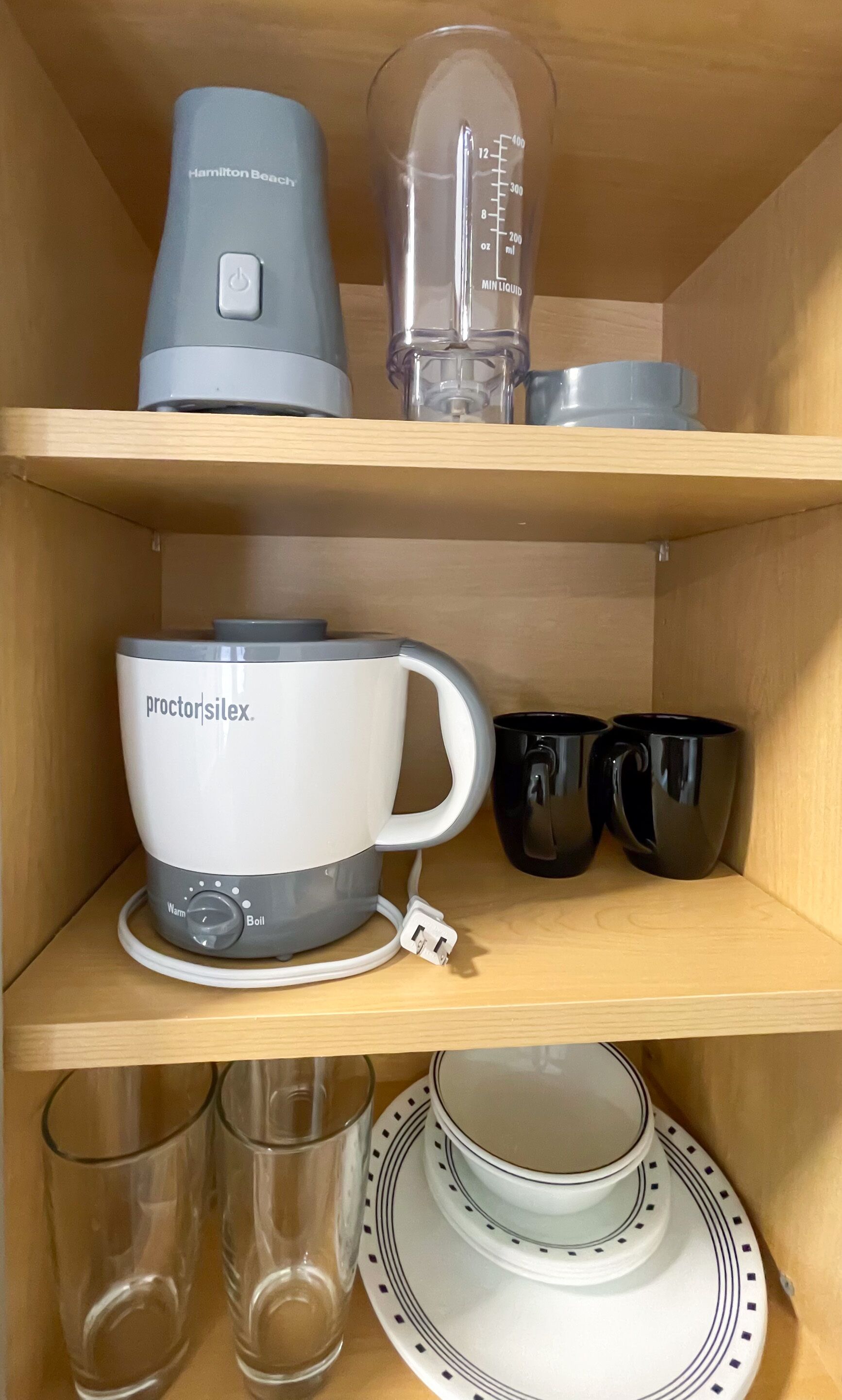En kökshylla med en kaffebryggare från Hamilton Beach, en mixer och en kaffekanna från Proctor Silex.