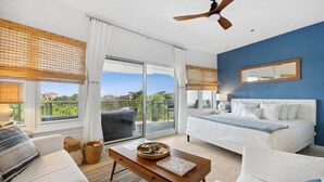 Une chambre avec un lit, un canapé, une table basse et un balcon offrant une vue.