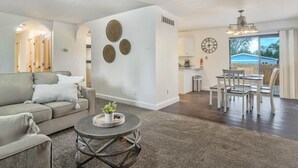 Ein modernes Wohnzimmer mit einer Couch, einem Couchtisch und einem Essbereich mit Stühlen.