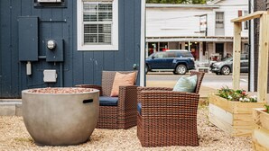 Un espace extérieur aménagé avec des meubles en osier et un grand bac à plantes.