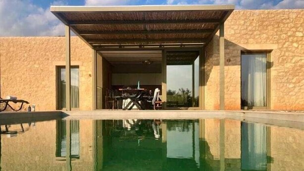 Un bâtiment moderne avec une piscine à l’avant.