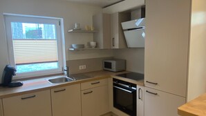 A modern kitchen with white cabinets, a built-in microwave, and a dishwasher.