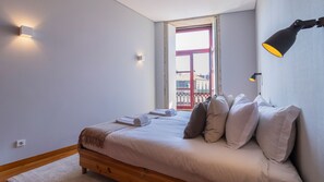 Relax in a serene bedroom with a neatly made bed, wooden headboard, and a bedside table with a lamp.