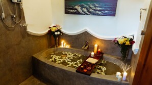A bathtub with candles, flowers, and a tray of toiletries. - Younger Villa (Ahangama)