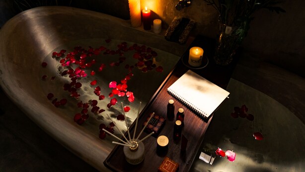 A bathtub with rose petals, candles, and toiletries. - Younger Villa (Ahangama)