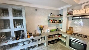 A modern kitchen with built-in shelves, a gas stove, and an oven. - Younger Villa (Ahangama)