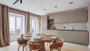 A modern kitchen with a round dining table and chairs, a built-in oven, and a large window with curtains. - Magnificent New Apartment  Beaubourg/Le Marais (Paris)