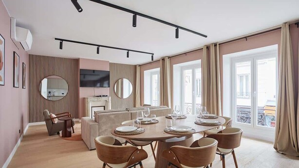 A modern dining area with a round table set for six, surrounded by wooden chairs. - Magnificent New Apartment  Beaubourg/Le Marais (Paris)