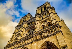 Uma grande catedral com esculturas em pedra detalhadas e múltiplas arcadas.