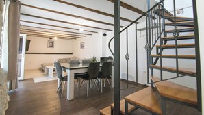 Un espacio de estar moderno con comedor, una escalera y vistas de la habitación contigua.