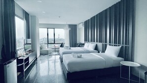 Habitación de hotel moderna con dos camas, un escritorio, una silla y vistas a la ciudad.