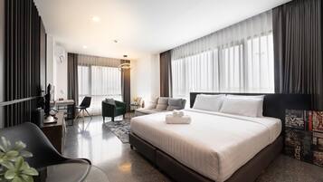 Une chambre d’hôtel moderne, dotée d’un grand lit, d’un bureau, d’une chaise et d’un canapé.
