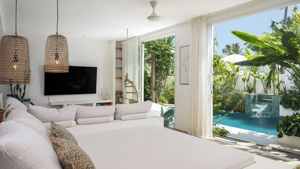 Un dormitorio amplio con una cama grande, televisión de pantalla plana y vistas a una piscina.