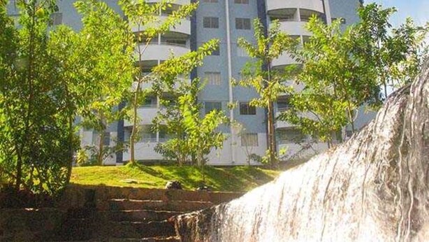 Ein Hotel mit Pool, Wasserfall und einem Gebäude mit mehreren Balkonen.