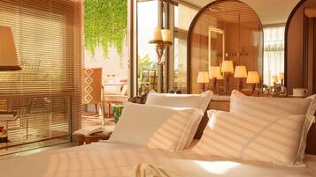 Habitación de hotel con cama, lámparas de noche, un espejo y vistas a zonas verdes.