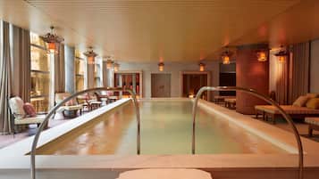 Una piscina techada, sillones reclinables de piscina