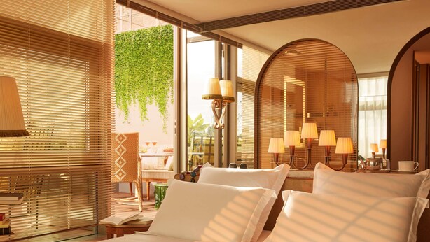 Habitación de hotel con cama, lámparas de noche, un espejo y vistas a zonas verdes.
