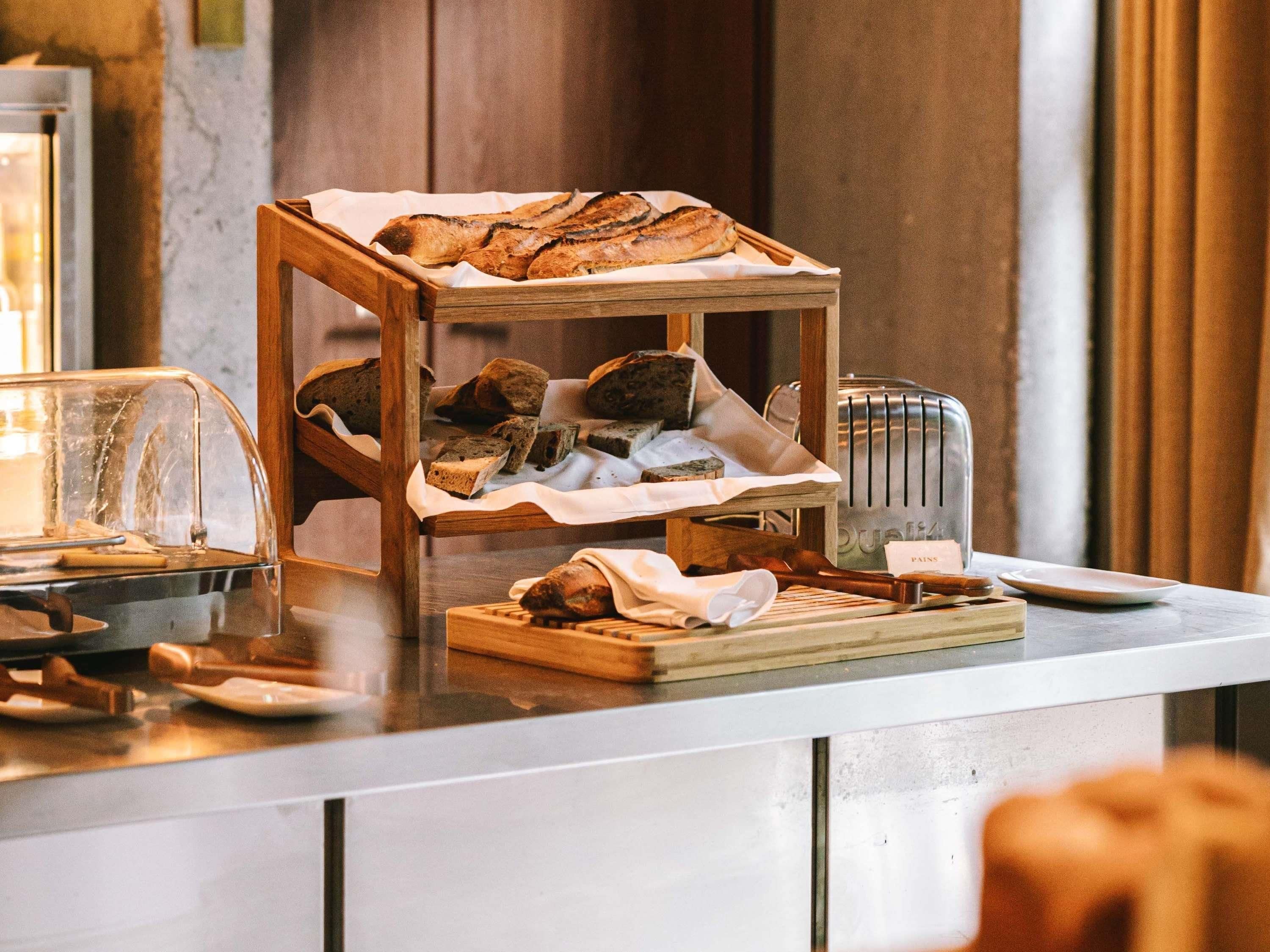 A breakfast buffet with bread, pastries, and a toaster.