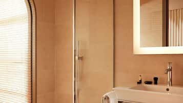 A bathroom with a shower, a sink, and a mirror.